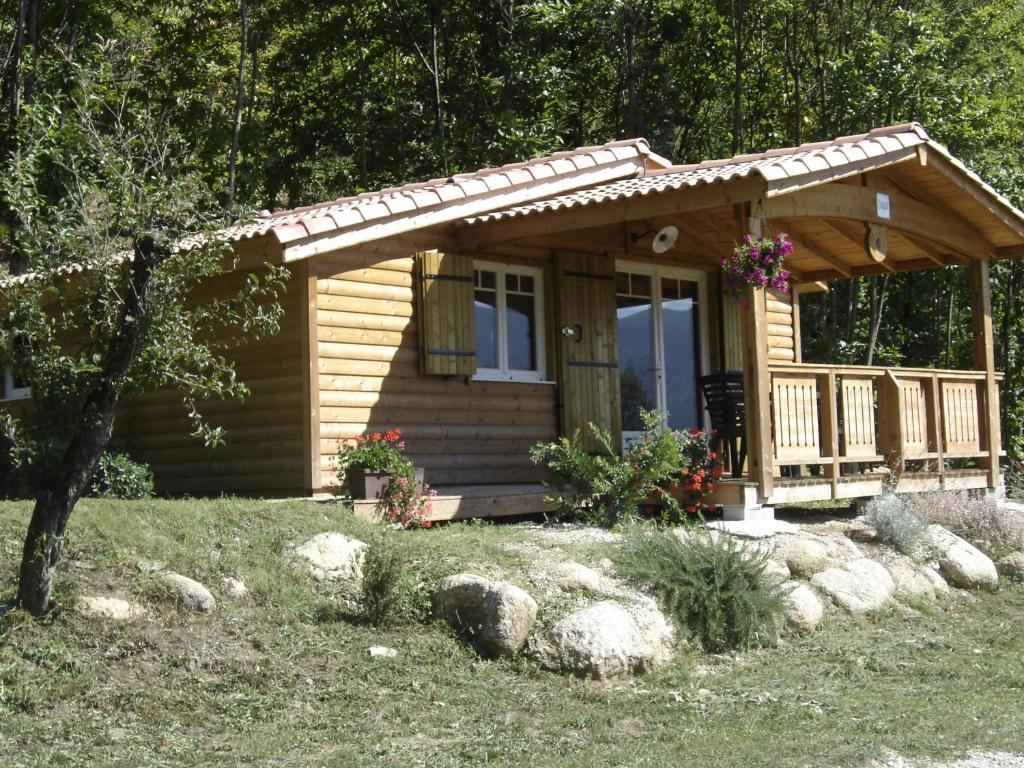 Cabaña de madera pequeña con porche y terraza en Domaine Lou Cevenol, en Aulas