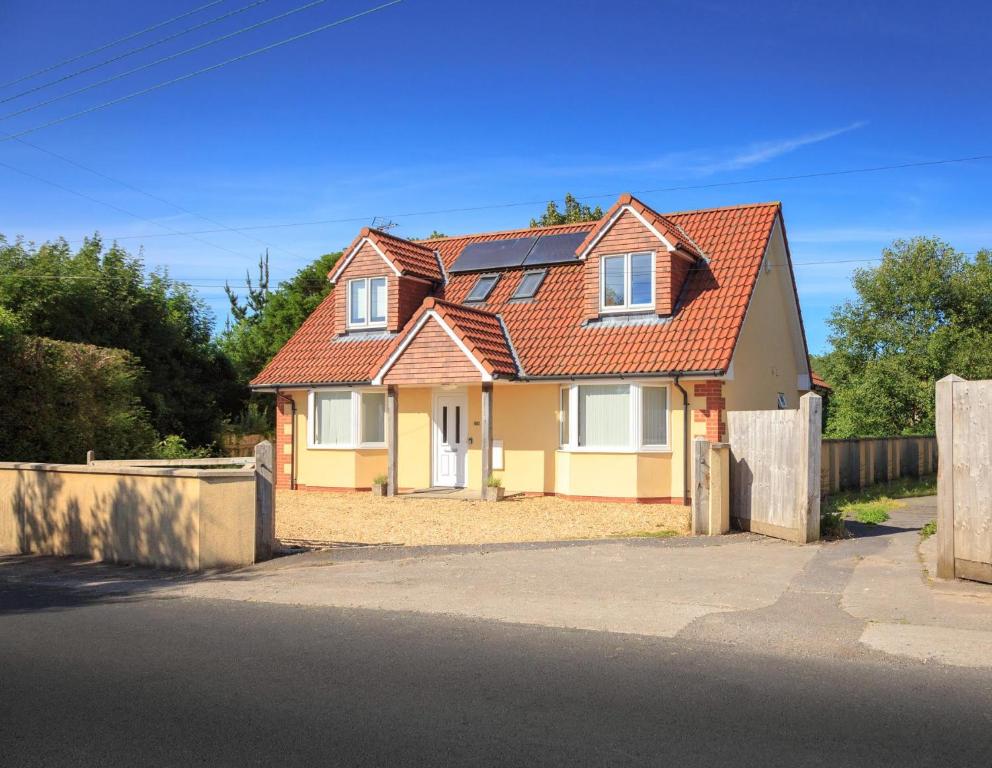 ein gelbes Haus mit rotem Dach auf einer Straße in der Unterkunft Cleeves Cottage in Bristol