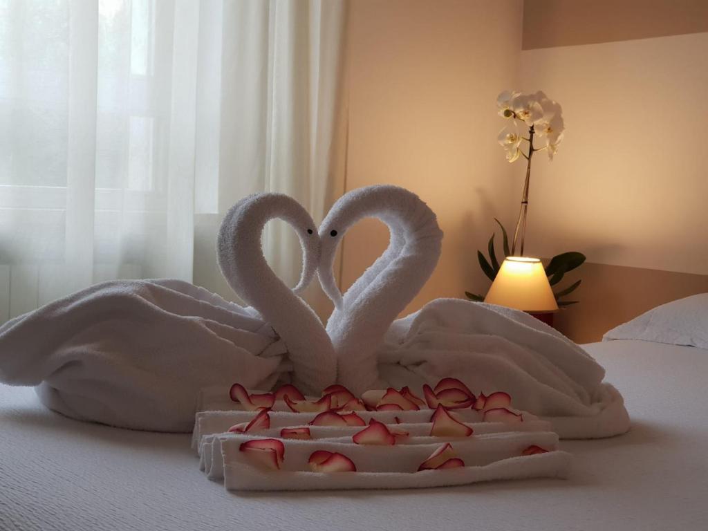two swansrendered to look like hearts on a bed at Residenza Miola in Saronno