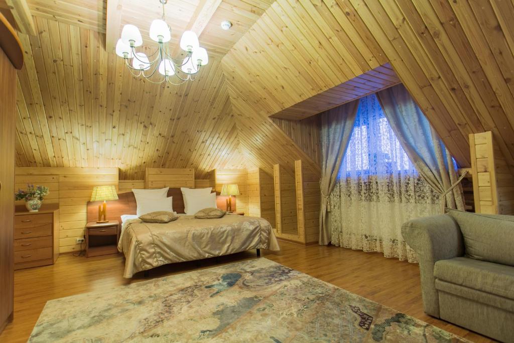 1 dormitorio con cama y lámpara de araña en Svetliy Terem Hotel en Suzdal