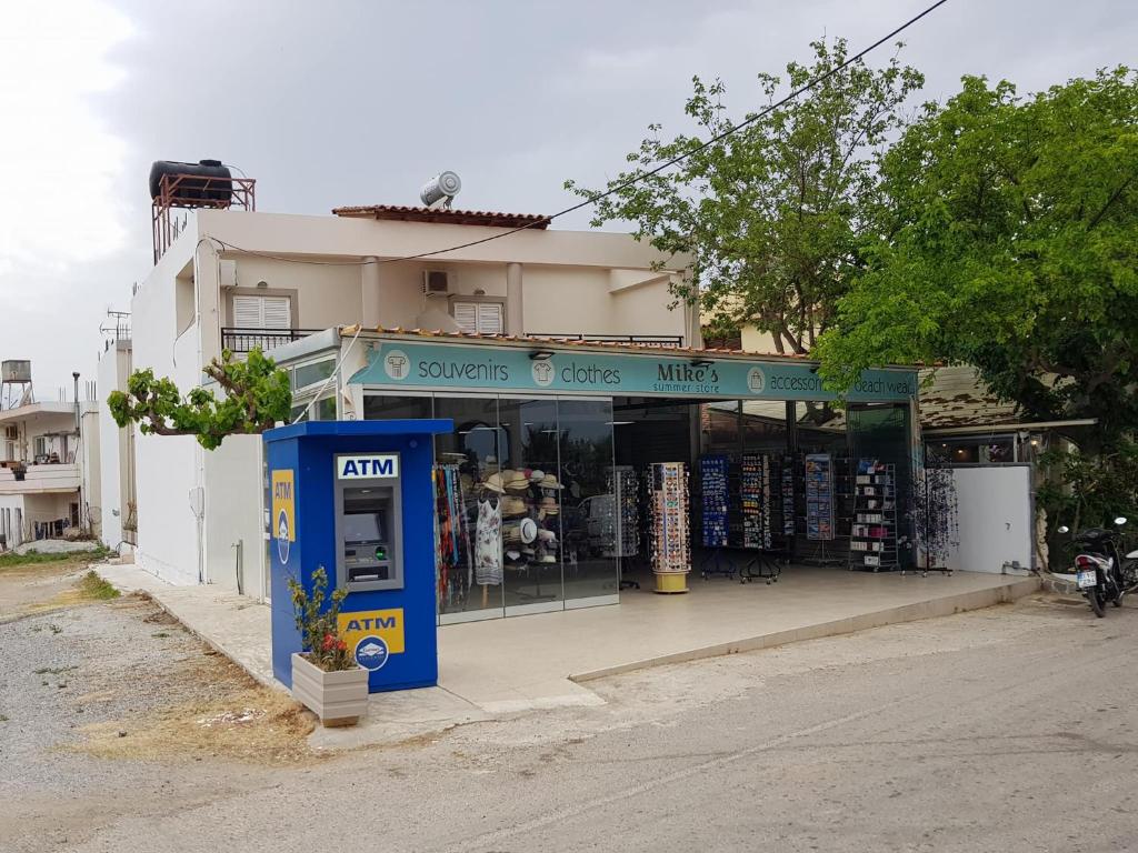 einen Laden mit einer blauen Telefonzelle davor in der Unterkunft Mikes Apartment in Georgioupoli