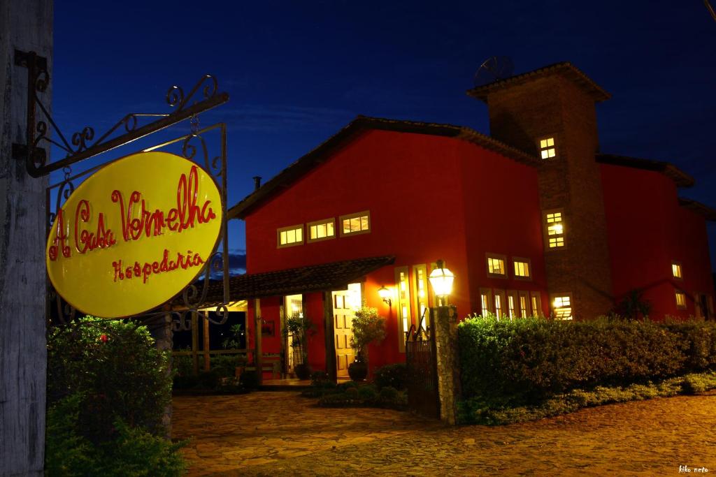 un restaurant avec un panneau en face d'un bâtiment dans l'établissement A Casa Vermelha Hospedaria, à Tiradentes