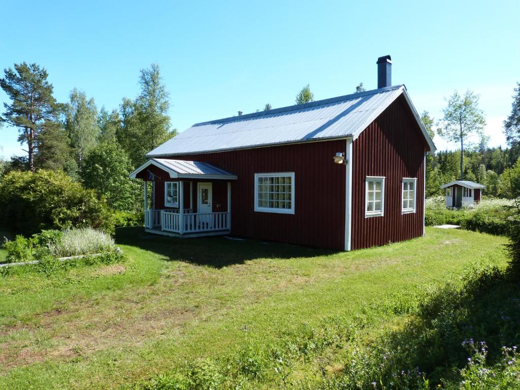 un granero rojo en un campo de hierba en Ferienhaus Brittsbo, en Ramvik