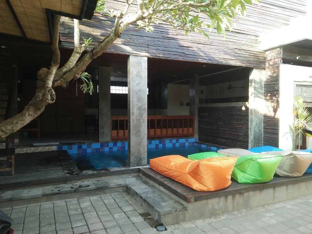 einen Sitzbereich im Freien eines Hauses mit einem Pool in der Unterkunft Made House Homestay and Dormitory in Sanur