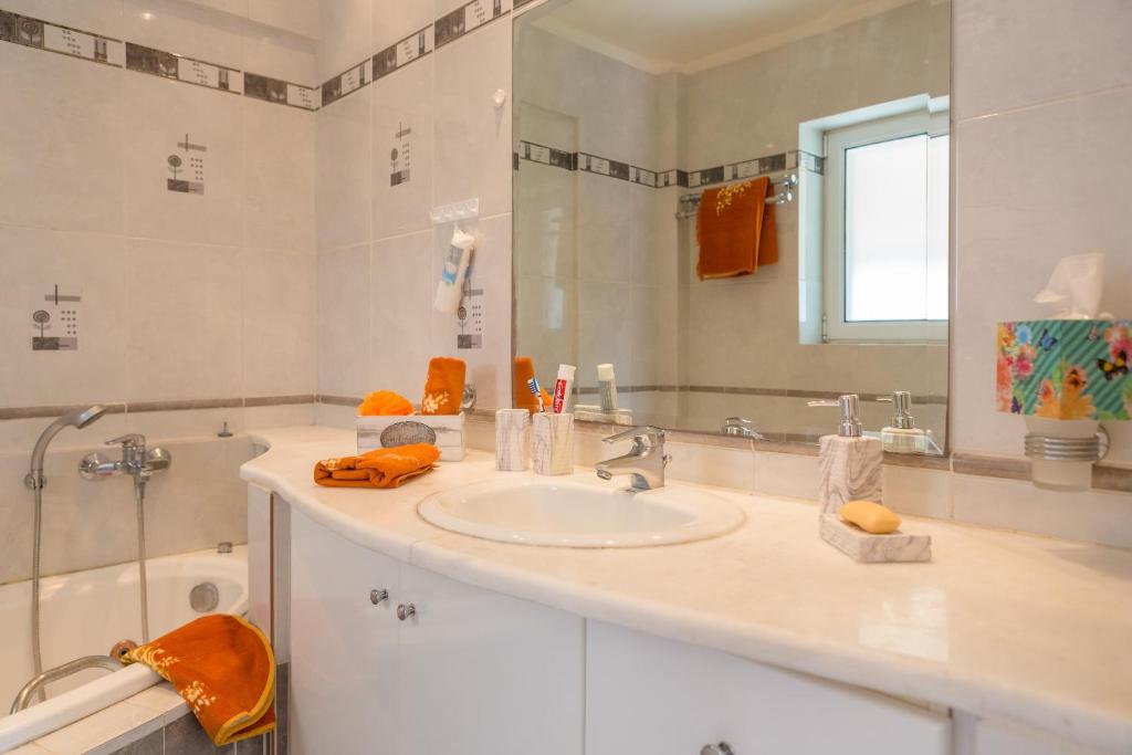 W łazience znajduje się umywalka, lustro i wanna. w obiekcie Villa Santa Barbara w mieście Maraton