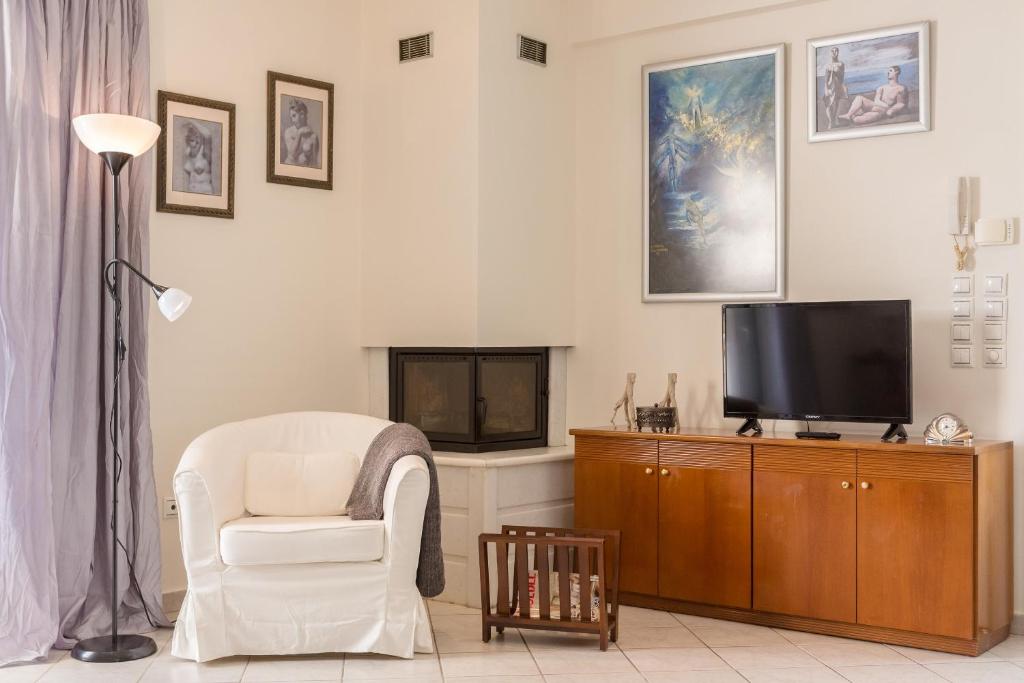 salon z krzesłem i telewizorem w obiekcie Villa Santa Barbara w mieście Maraton