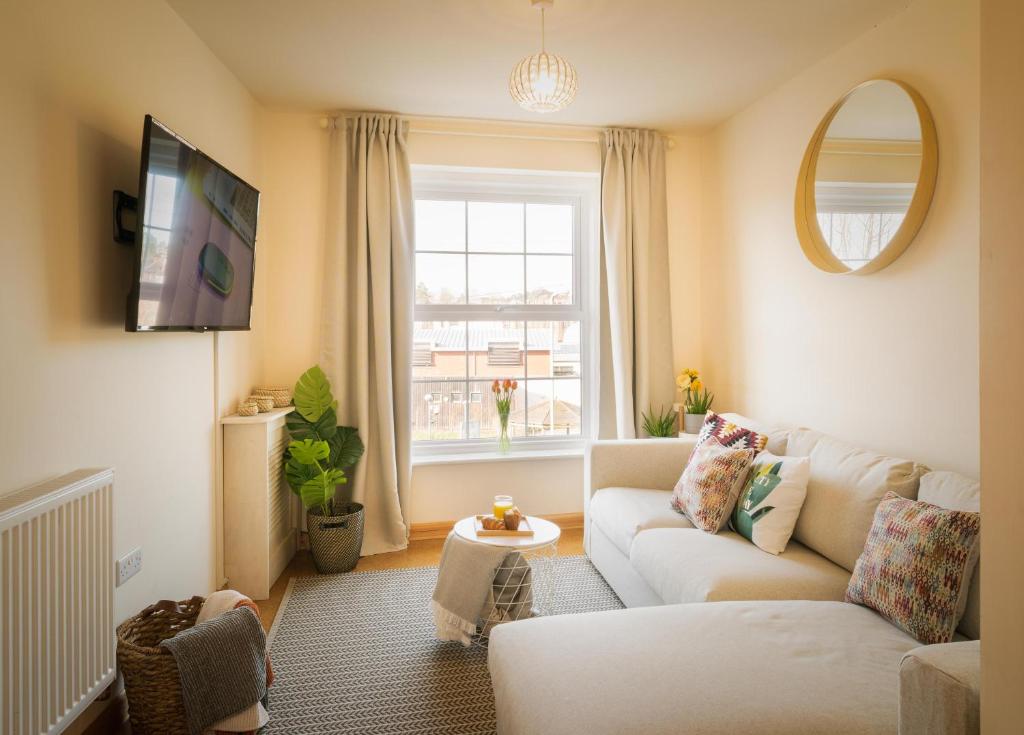 a living room with a white couch and a window at St Sidwells Townhouses' in Exeter