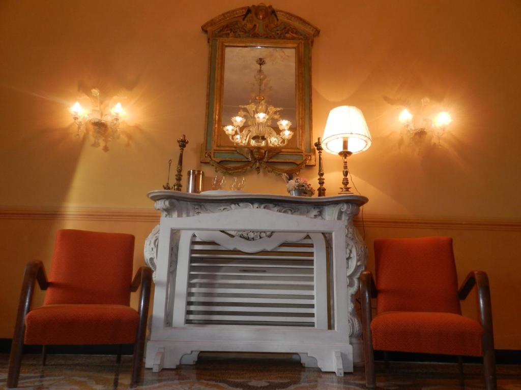 uma lareira num quarto com duas cadeiras e um espelho em Bigo Guest House em Génova