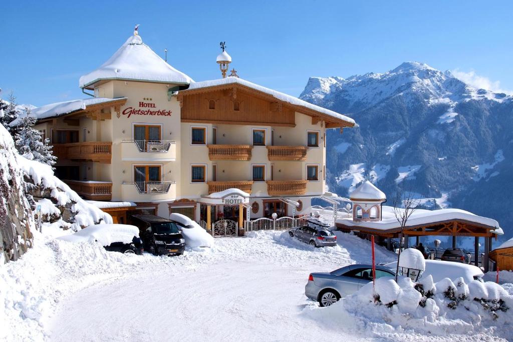 a snow covered building with a car parked in front of it at Hotel Gletscherblick in Hippach