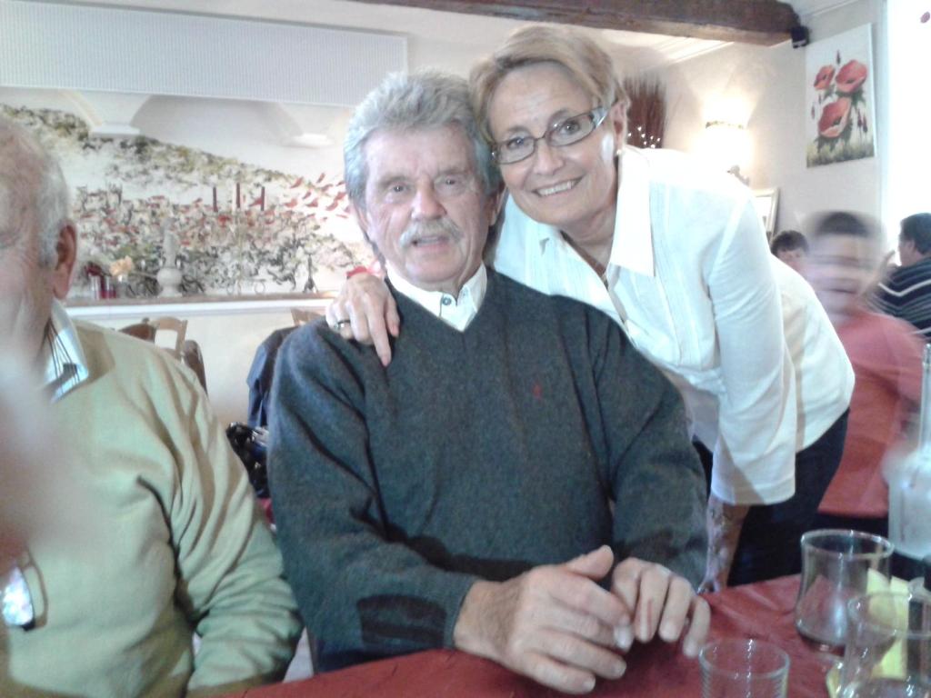 un hombre mayor sentado en una mesa con una mujer en Chambre Locéanaïs en Régusse
