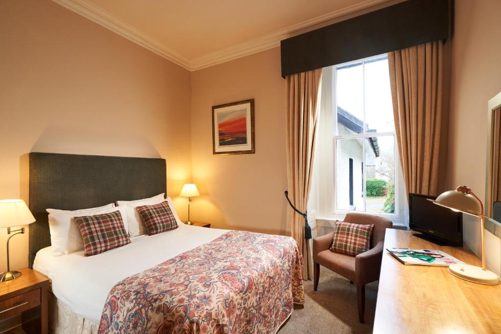 a hotel room with a bed and a desk at Poppies Hotel in Callander