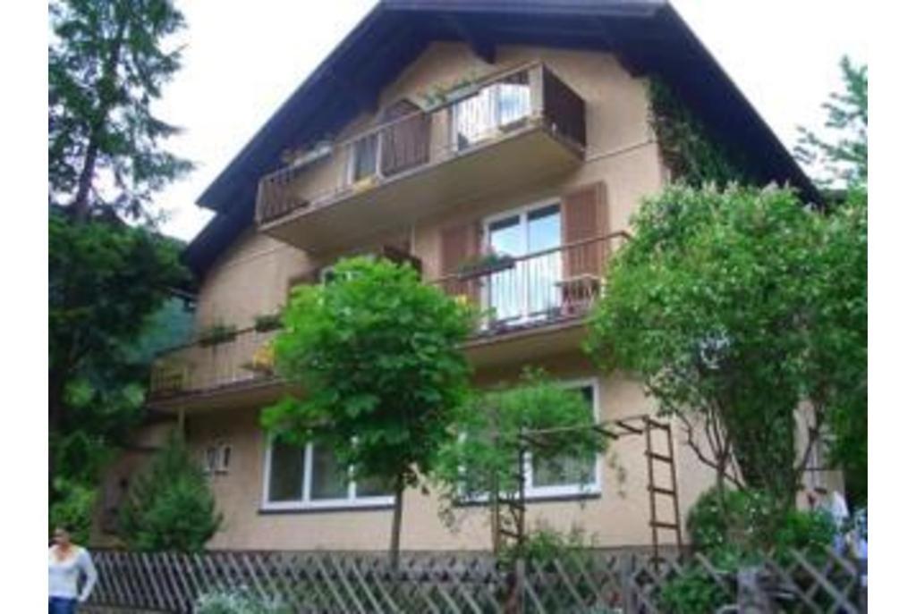 a building with a balcony and a tree in front of it at Pension Charlotte in Bad Gastein