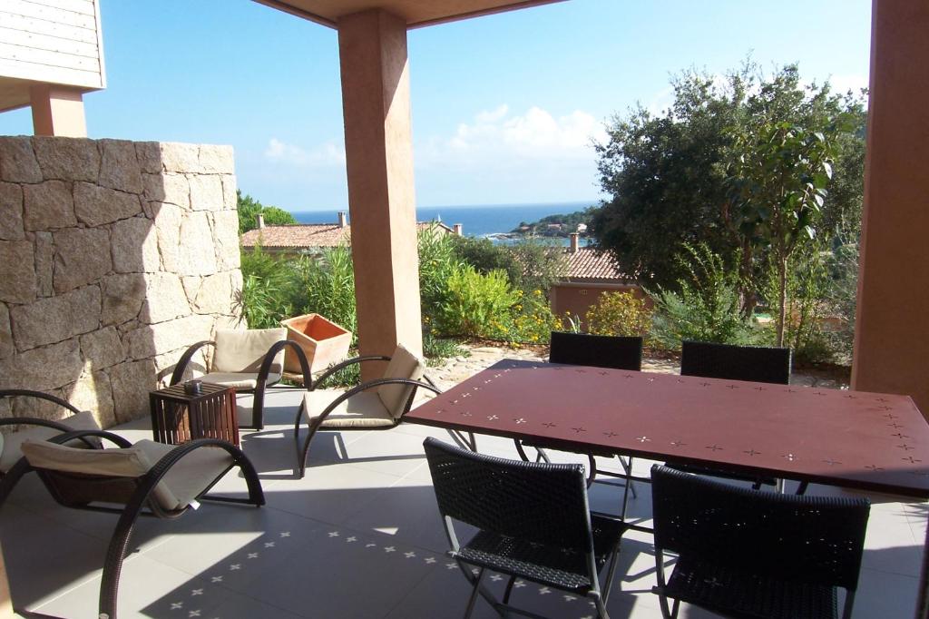 una mesa y sillas en un patio con vistas al océano en ALMA, en Conca