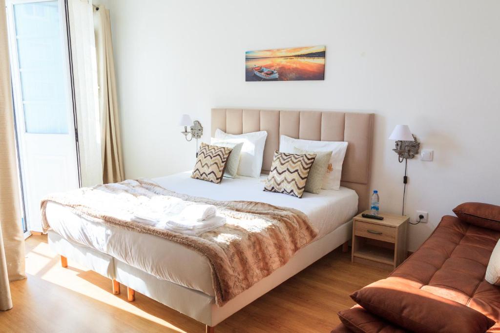 um quarto com uma cama e um sofá em Soldouro Guesthouse em Aveiro