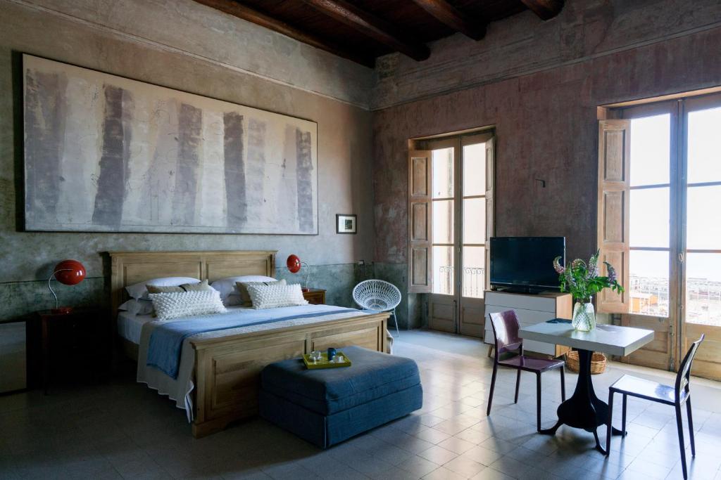 サレルノにあるStarhost - Trotula Charming Housesのベッドルーム1室(ベッド1台、テーブル、椅子付)