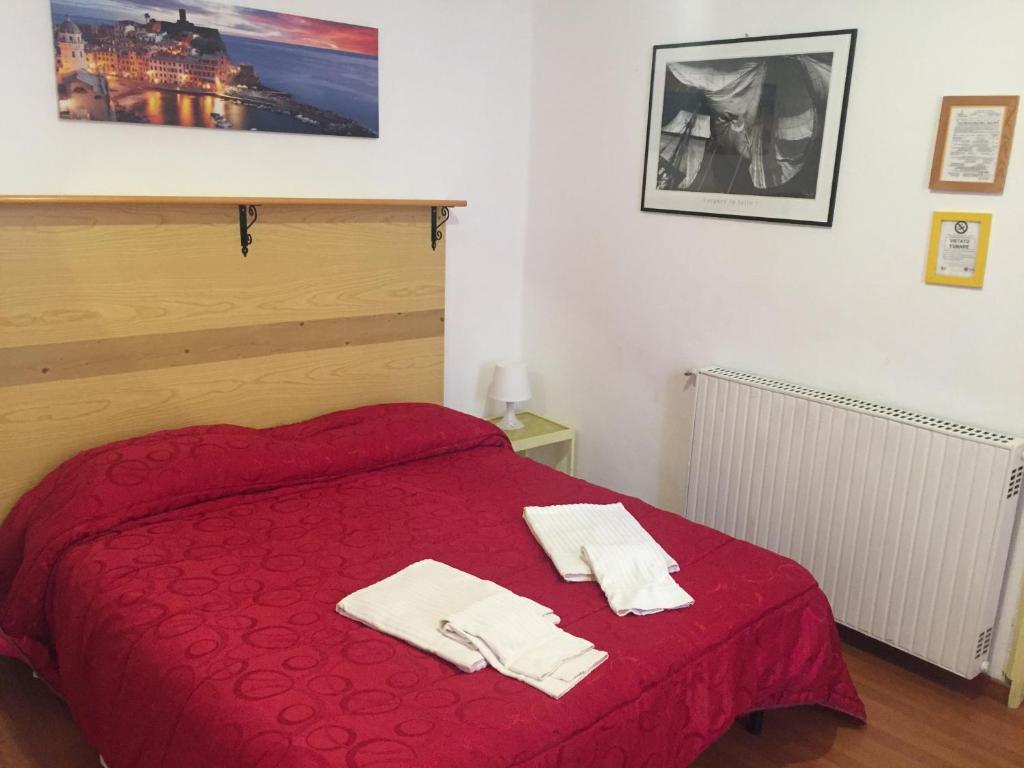 sypialnia z czerwonym łóżkiem i 2 ręcznikami w obiekcie Hotel Villa Cristina w Rapallo