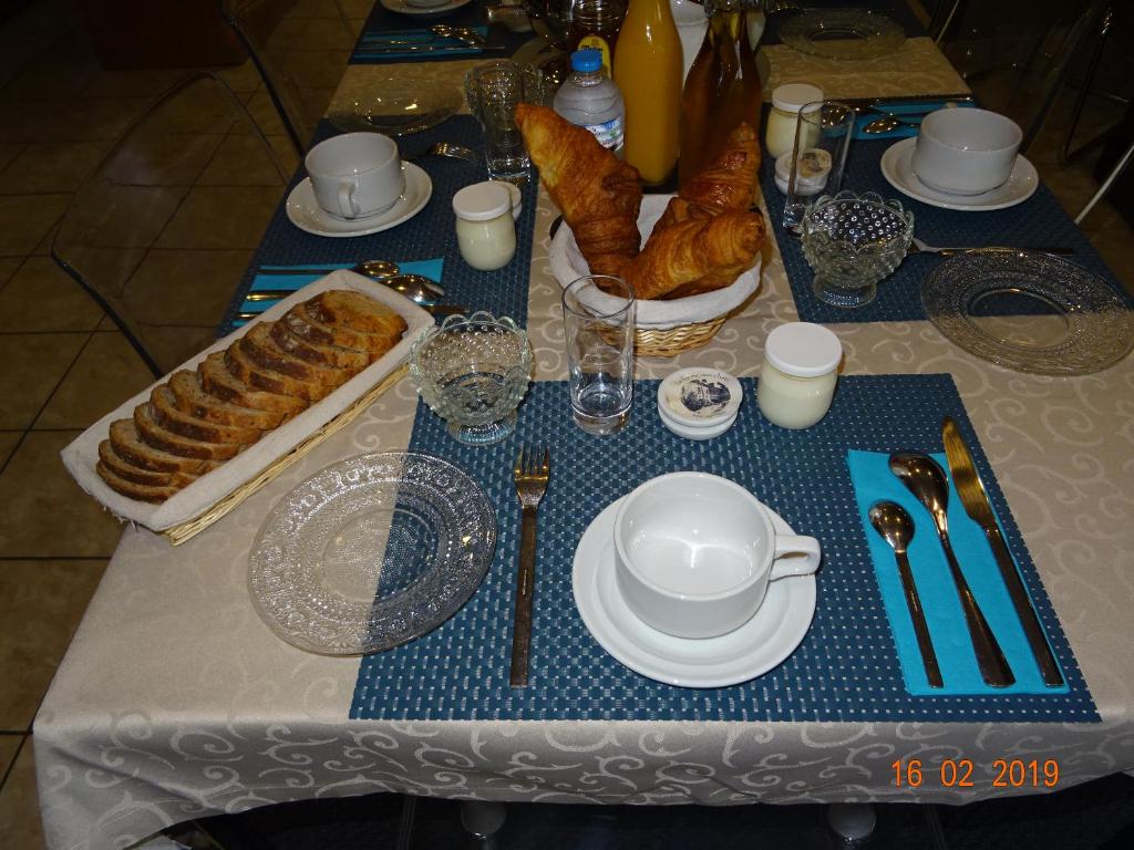 a table with a blue and white table set with pastries at La ferme aux chats in Formigny