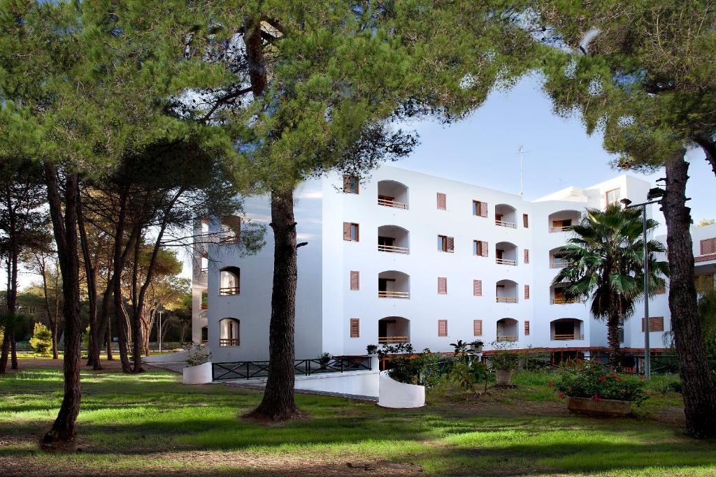 a large white building with trees in front of it at GH Campoverde Village in San Cataldo