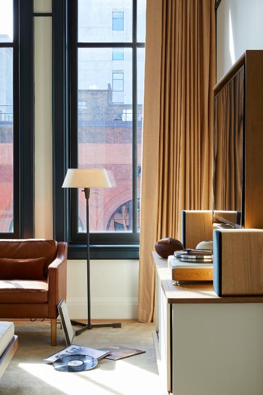 a living room with a chair and a window at Shinola Hotel in Detroit