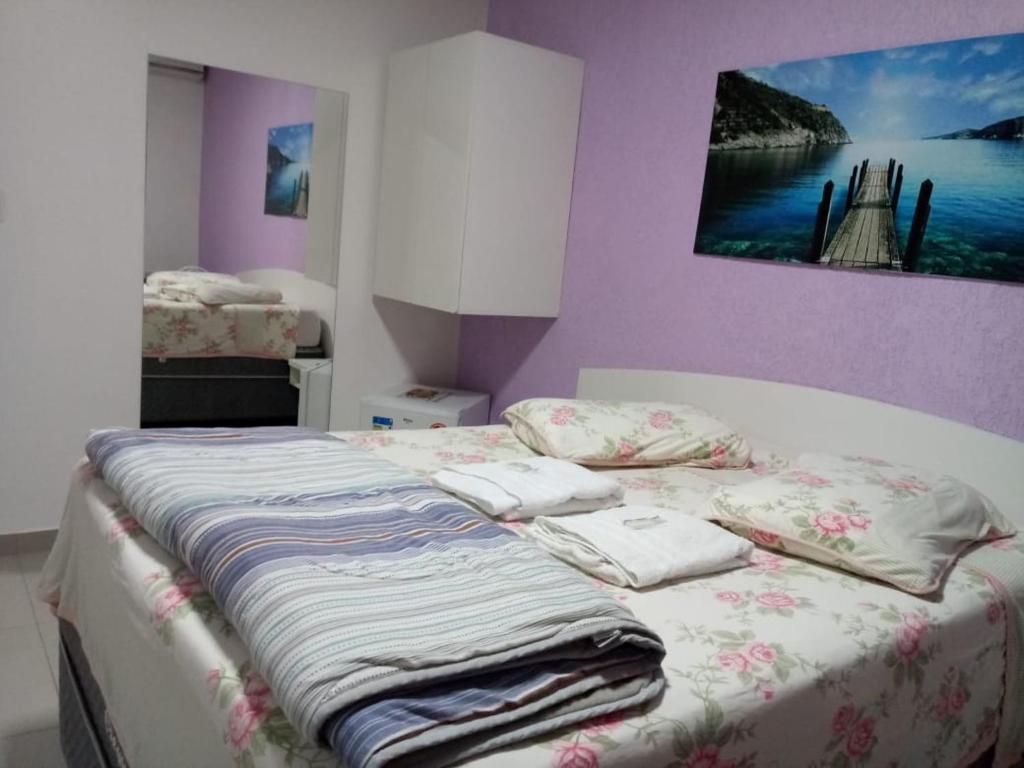 een bed met kussens in een slaapkamer bij Hotel Farrapos in Porto Alegre