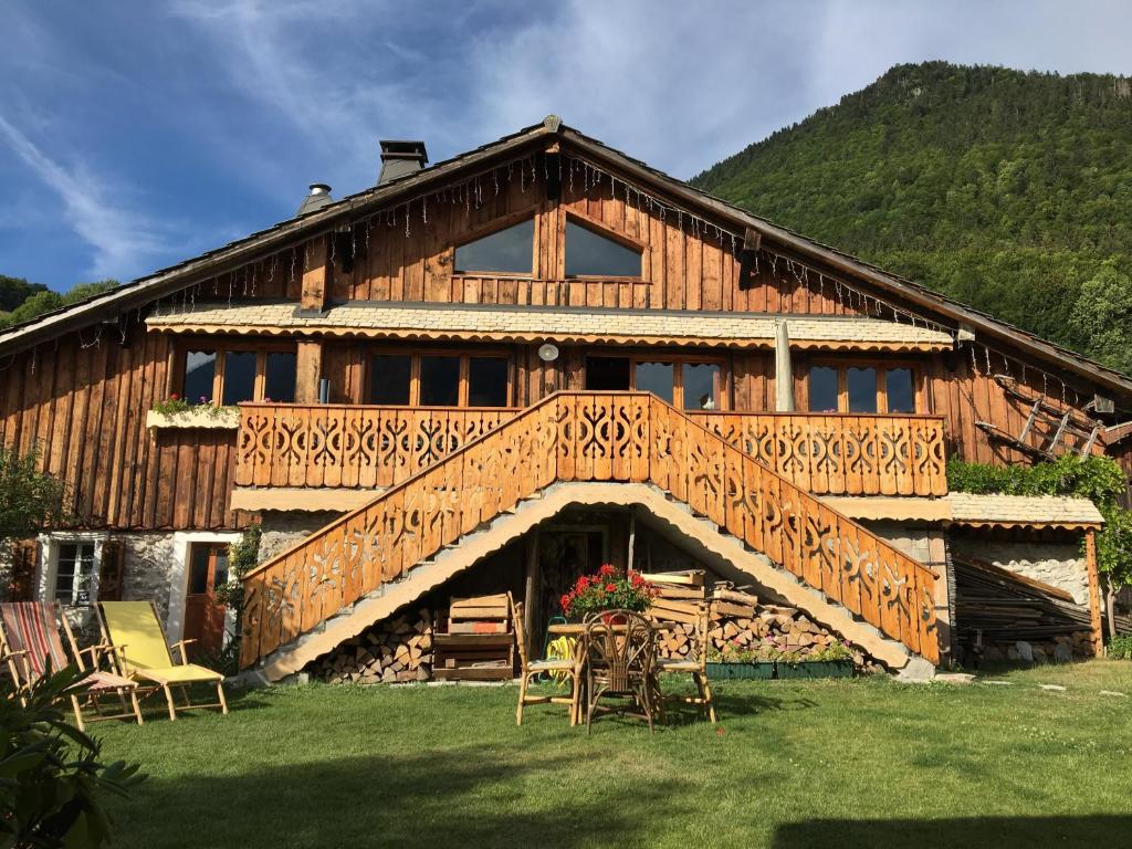 a large wooden house with a large deck at Les Sapins Blancs in Vacheresse