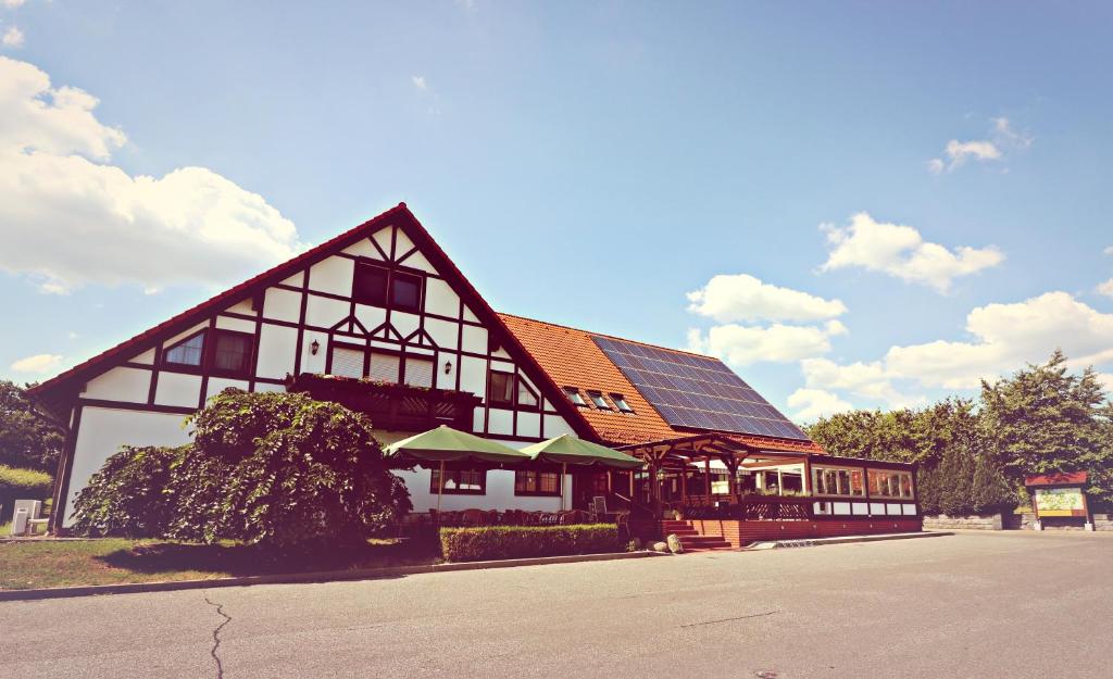 a large building with a solar roof on a street at Landhotel Krausnick in Krausnick