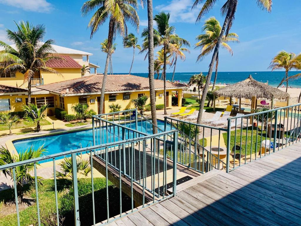 a view of a resort with a swimming pool and the ocean at Ebb Tide Resort in Pompano Beach