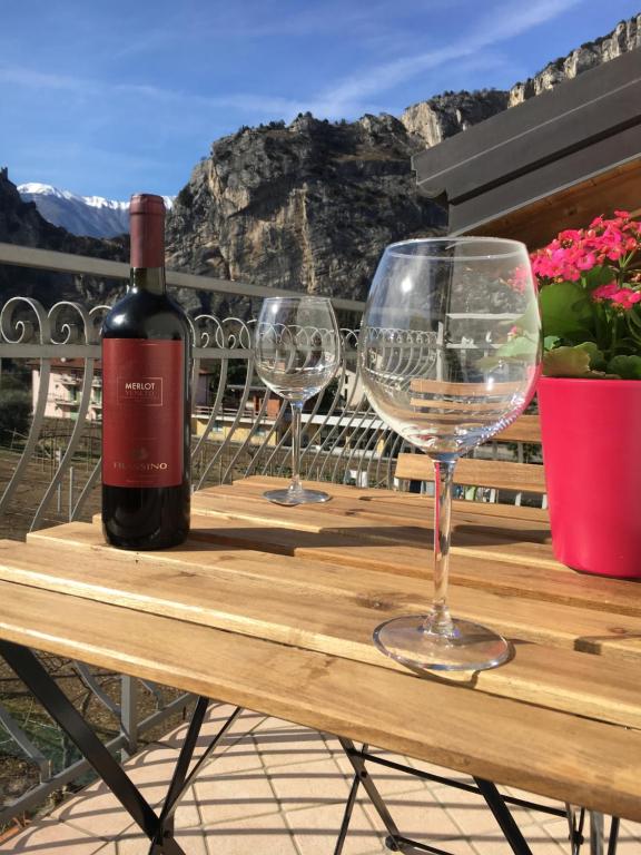 una bottiglia di vino e due bicchieri di vino su un tavolo di legno di Le Falesie ad Arco