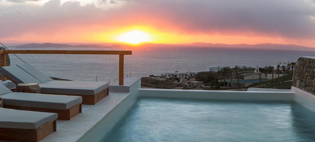 una piscina con vistas al océano al atardecer en VILLA ATHENA- Private Pool- Amazing Aegean View en Fanari