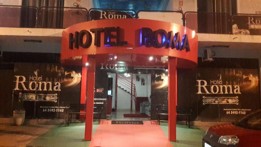 een rood hotelbord voor een winkel bij Hotel Roma in Edéia