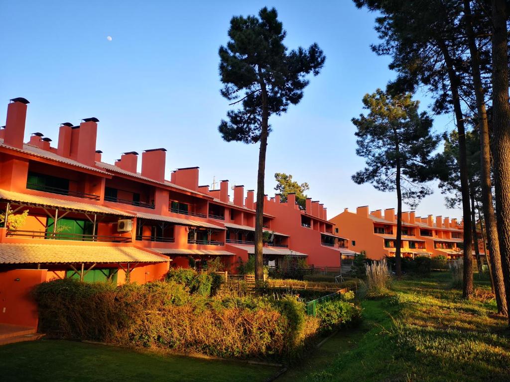 een groot rood gebouw met bomen ervoor bij Amazing View in Charneca