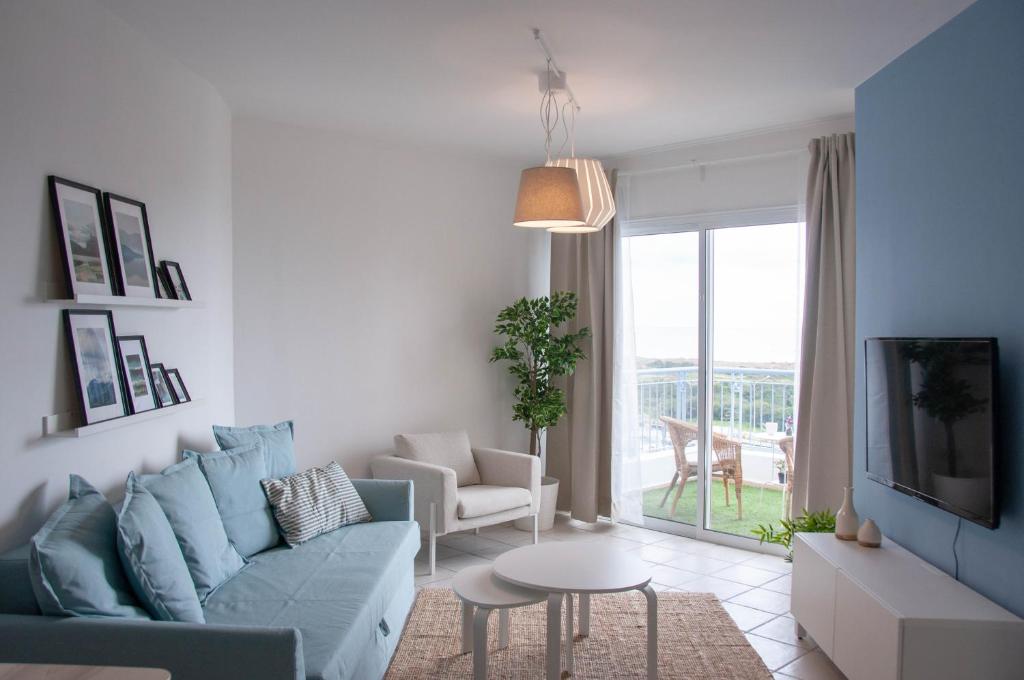 een woonkamer met een blauwe bank en een tv bij Best Apt In Paphos! in Paphos City
