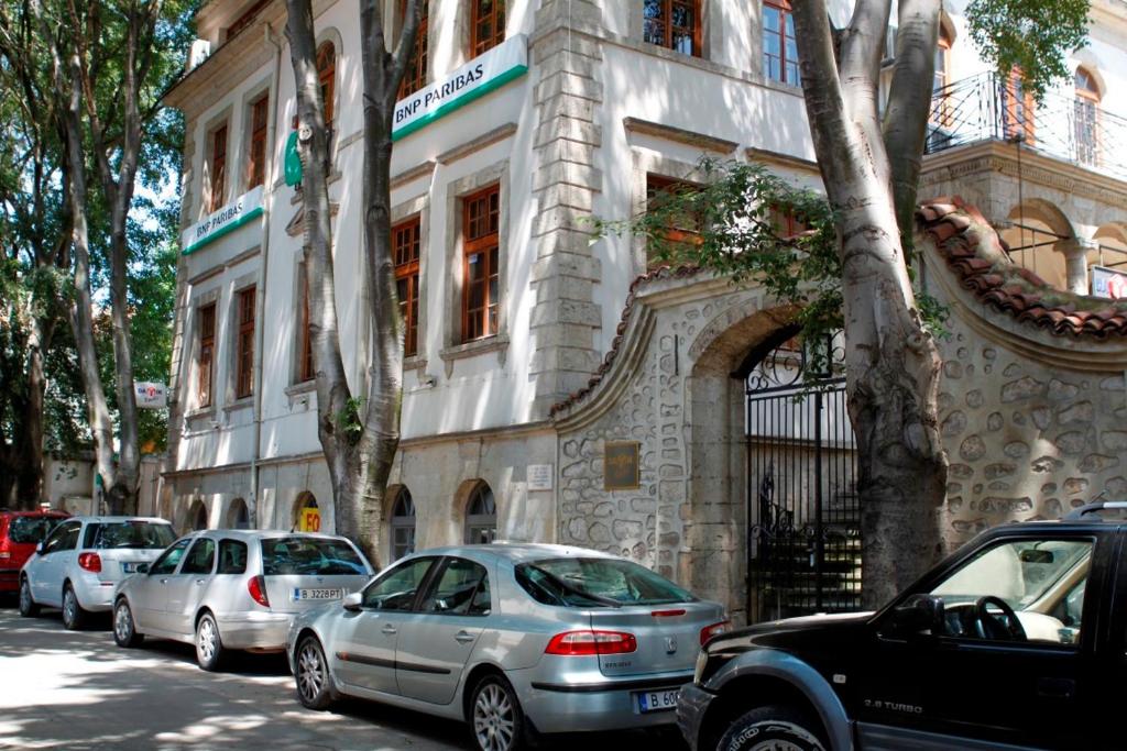 een groep auto's geparkeerd voor een gebouw bij Citadel Guest House in Varna