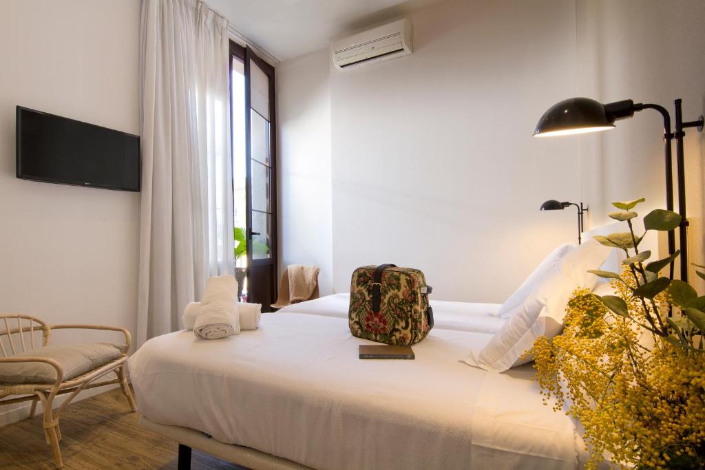 um quarto com uma cama com uma mala em Som Nit Born em Barcelona