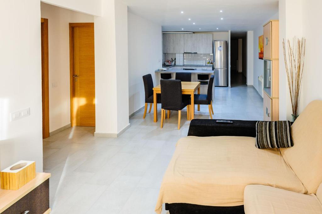 ein Wohnzimmer und eine Küche mit einem Sofa und einem Tisch in der Unterkunft Carrer Sevilla in Tarragona