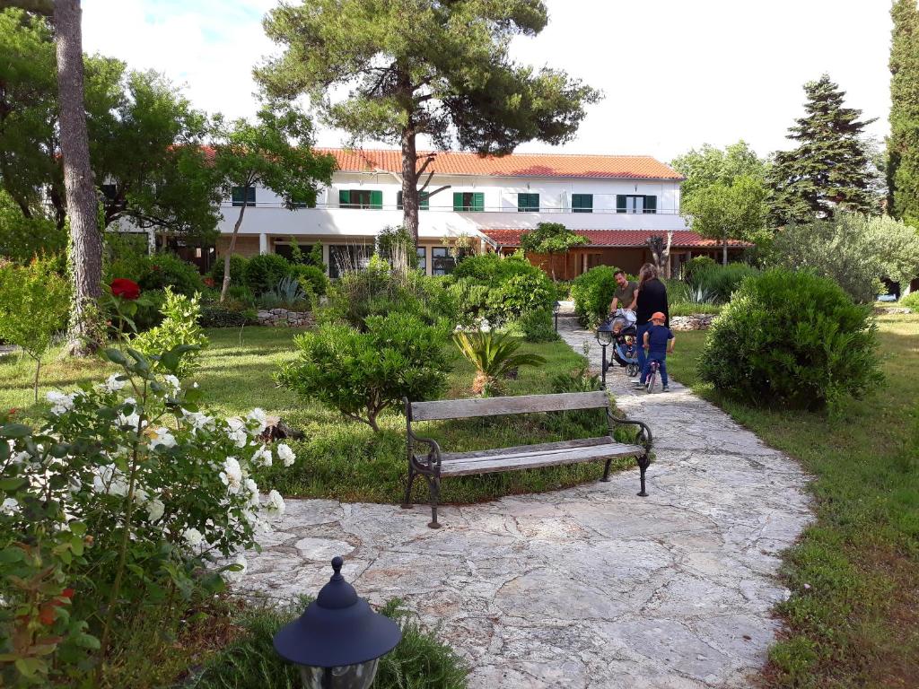a group of people sitting on benches in a park at Kleine Hexe B&B Pension in Pirovac