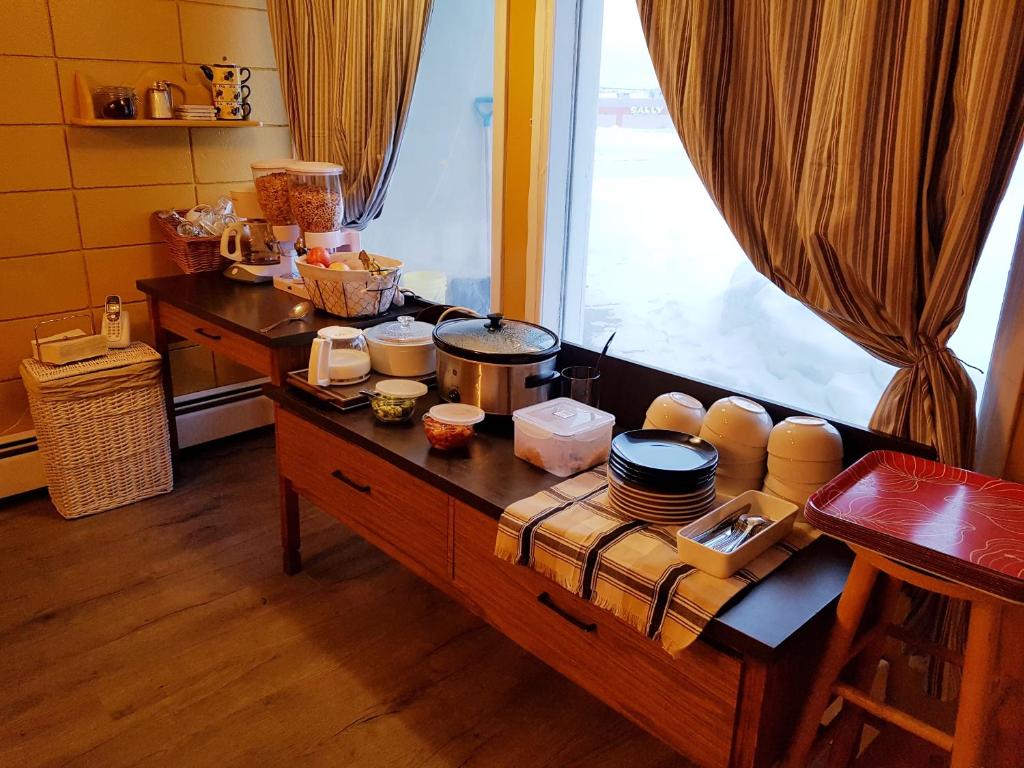 a kitchen with a table with dishes on it at Caravan Motel in Fort Saint John