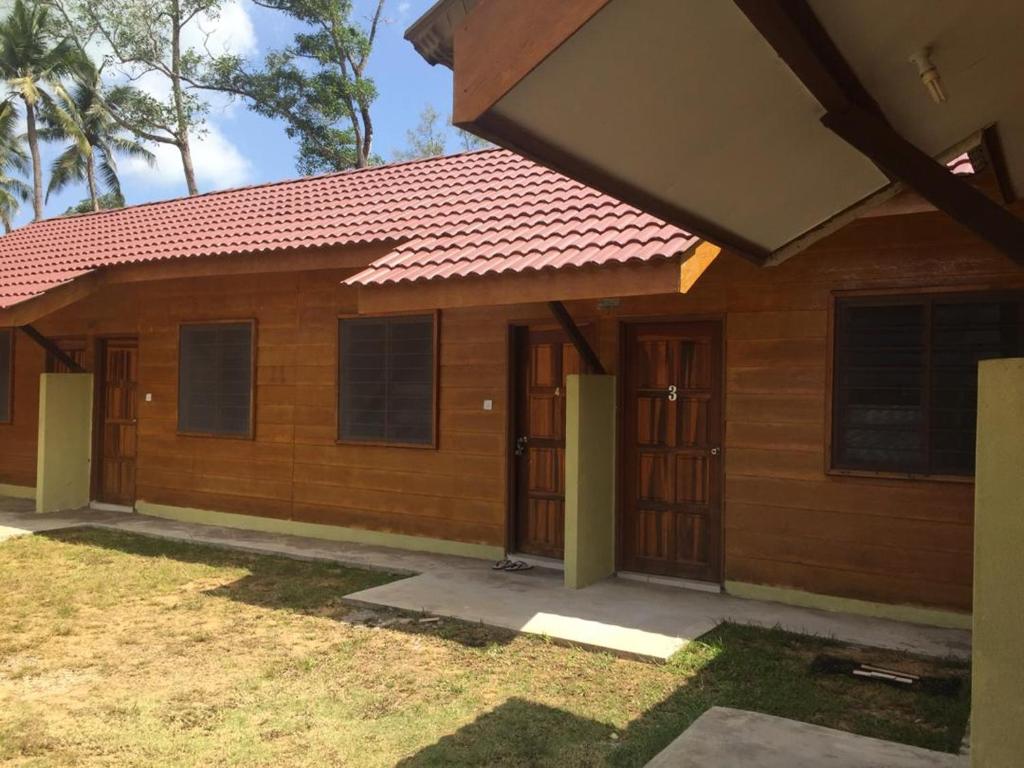 una pequeña casa de madera con techo rojo en Santai Lots Cherating, en Kuantan