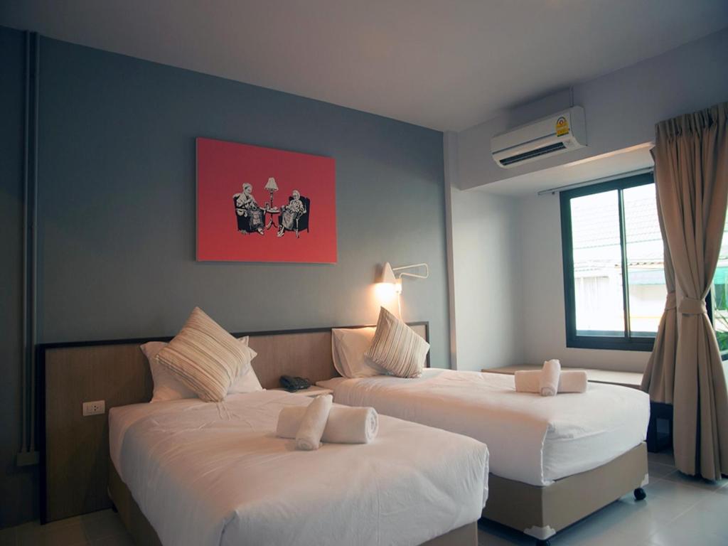 two beds in a hotel room with at Chalong Sea Breeze in Chalong