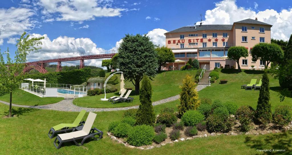 a resort with a park with chairs and a building at Logis Hôtel Beau Site in Loubaresse