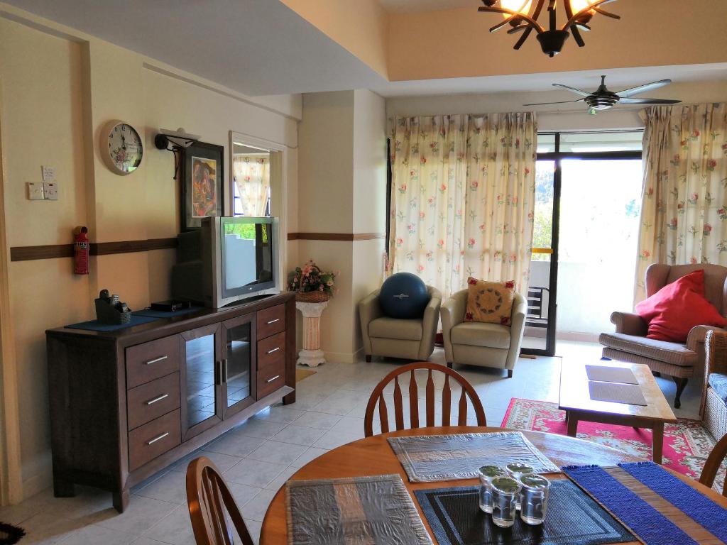 uma sala de estar com uma televisão e uma mesa de jantar em Genting Sempah Berjaya Hill em Bukit Tinggi