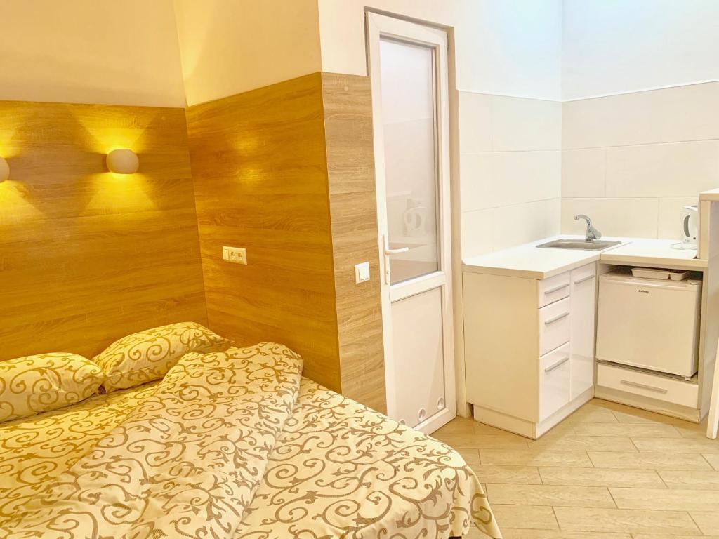 um pequeno quarto com uma cama e um lavatório em Smart apartments in the city center -5 min to the Opera House em Lviv