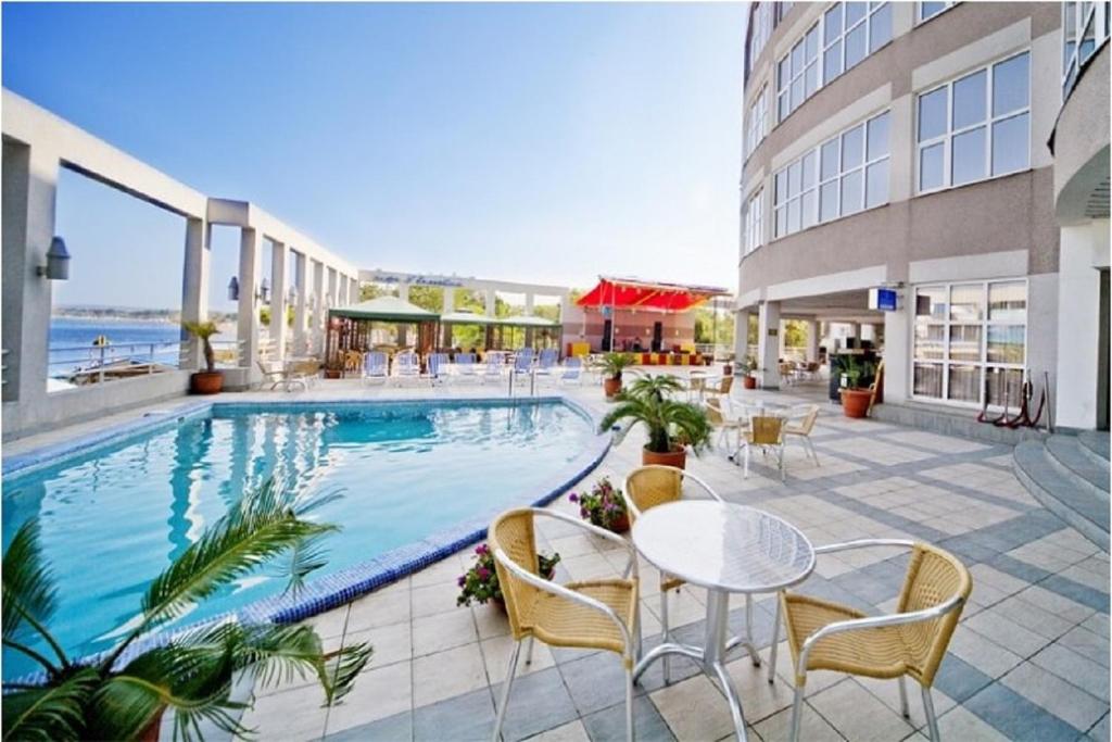 アナパにあるパーク ホテル アナパのテーブルと椅子付きのホテルのプールを利用できます。