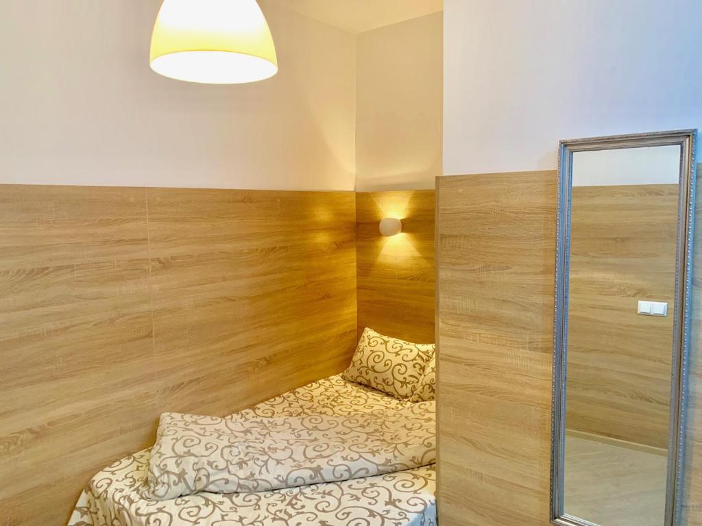 Habitación con cama con pared de madera en Mini- Smart апартаменти в центральній частині Львова, en Leópolis