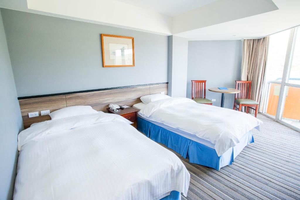 Ein Bett oder Betten in einem Zimmer der Unterkunft CT Green Bay Hot-Spring Hotel