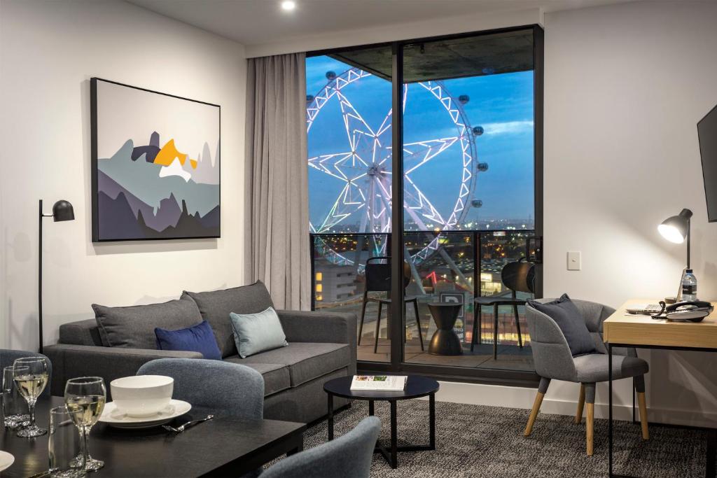 a living room with a couch and a large window at Quest NewQuay in Melbourne