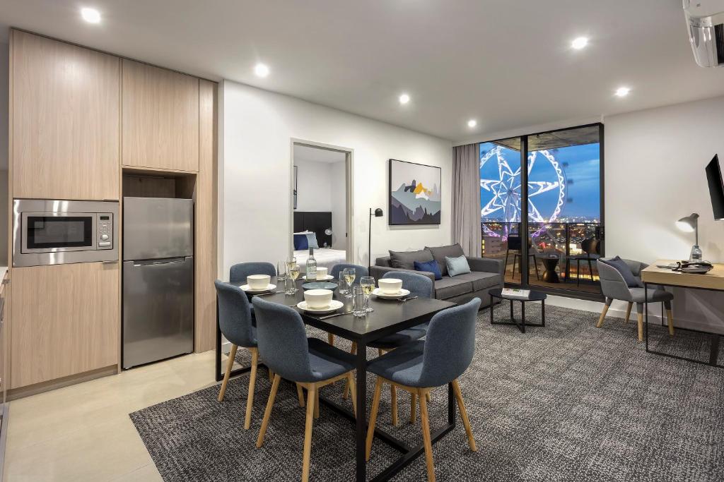 a kitchen and living room with a table and chairs at Quest NewQuay in Melbourne