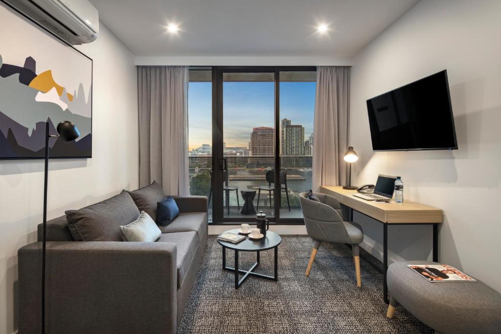 a living room with a couch and a desk at Quest NewQuay in Melbourne