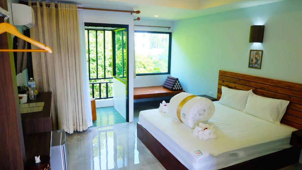 a bedroom with a bed with two stuffed animals on it at The Stamp Hotel in Koh Tao
