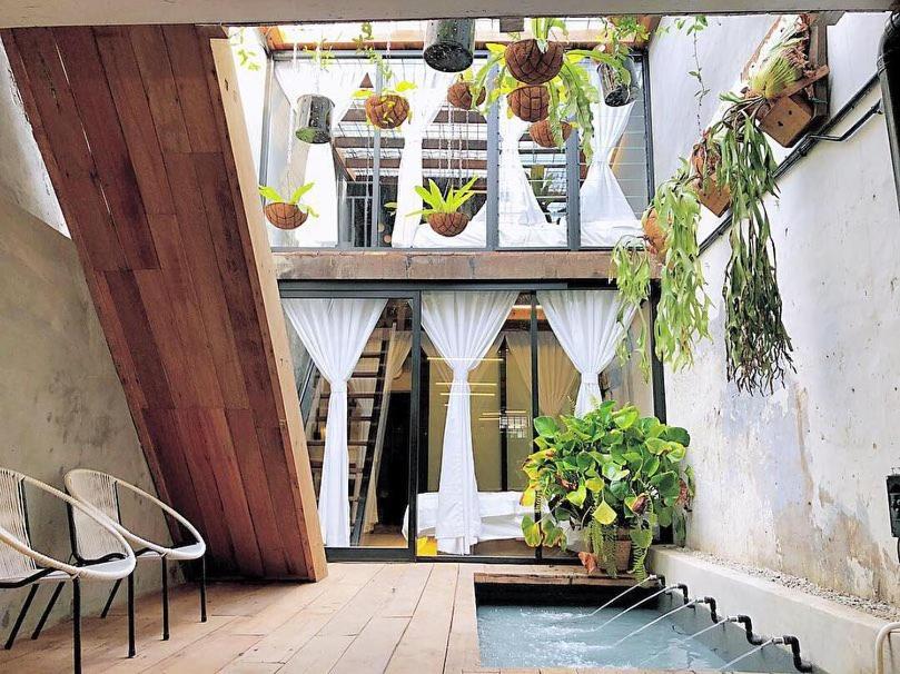 d'un balcon avec une table, des chaises et des plantes. dans l'établissement Rimba Jonker, Melaka Heritage Residance, à Malacca